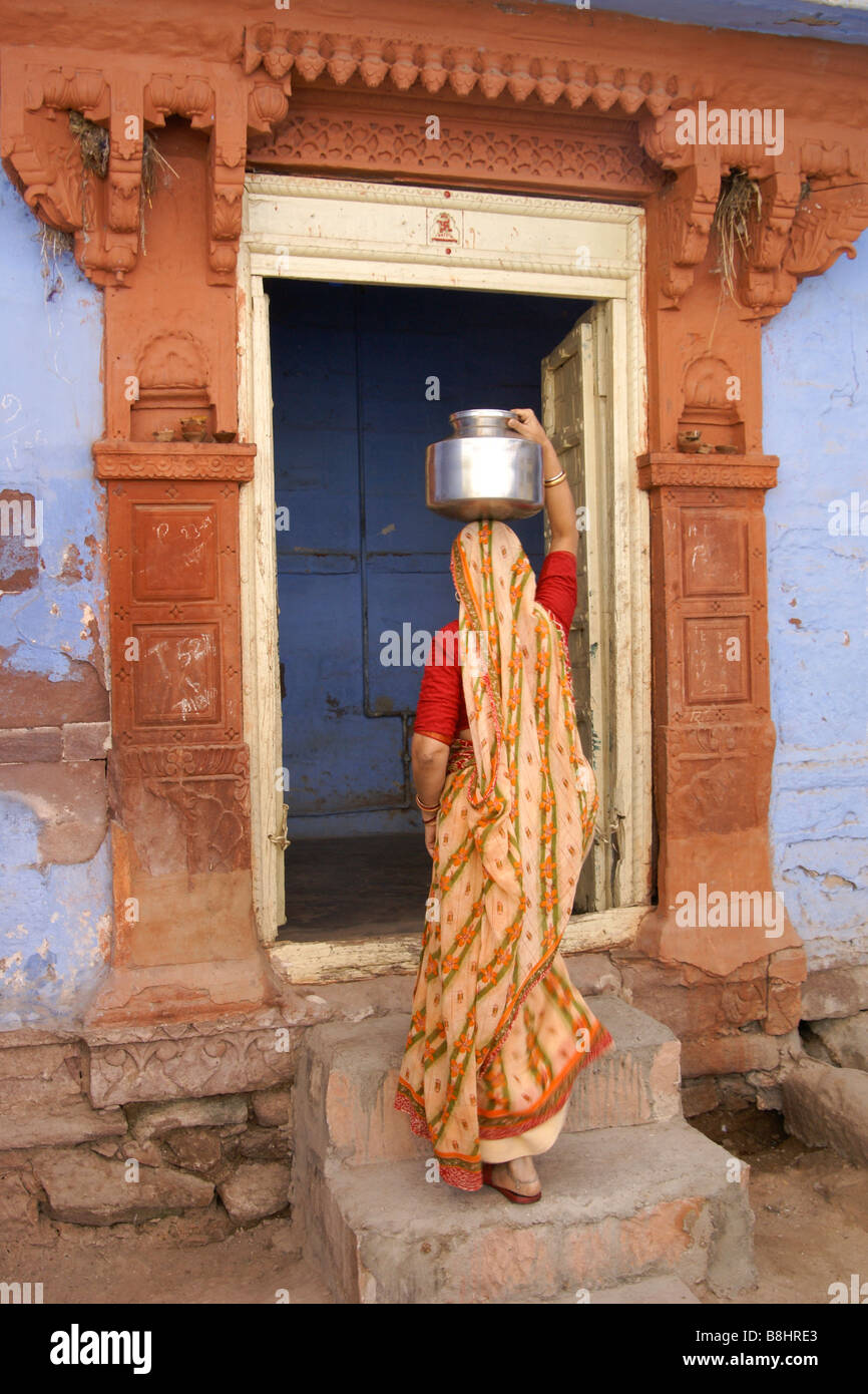 Frau mit Wasser ins Haus, "Blaue Stadt" in Jodhpur, Rajasthan, Indien Stockfoto