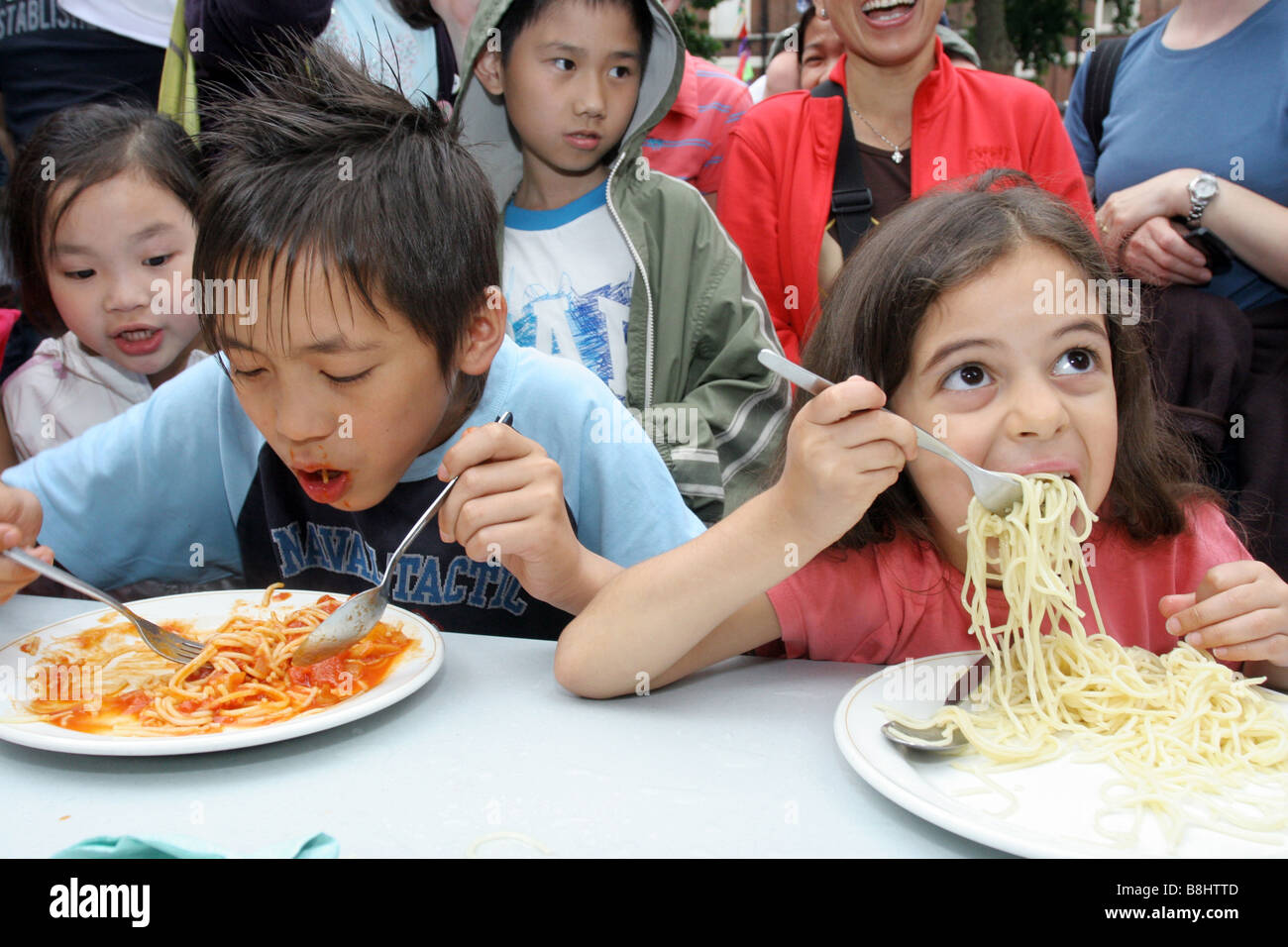 Kinder teilnehmen an eine Spaghetti Wettessen Stockfoto