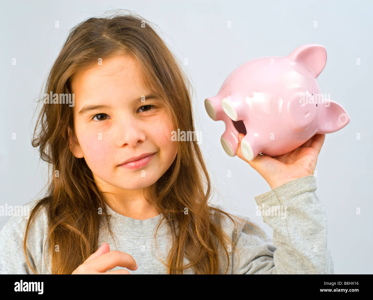 Mädchen schütteln ein Sparschwein Stockfoto