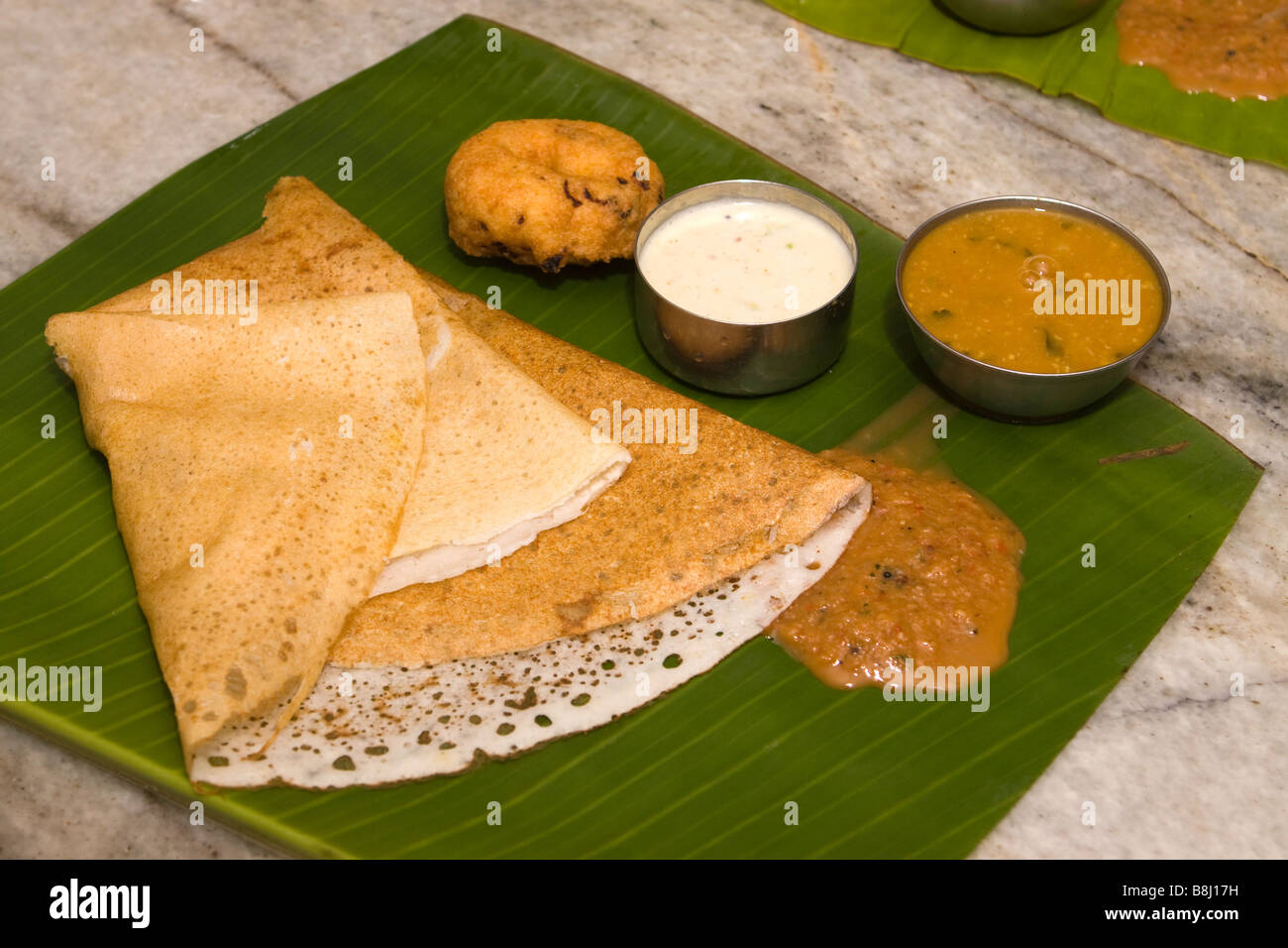 Indien Tamil Nadu Cancun South Indian frühstück Dosa sambar Chutney und Vadai serviert auf Banana leaf Platte Stockfoto