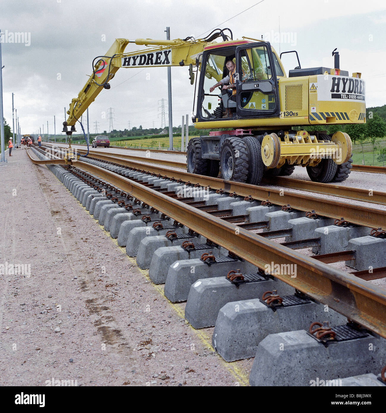 Auftragnehmer mit Zweiwege-Maschine, um lange Längen von geschweißten Schiene auf den ständigen Schwellen auf Channel Tunnel Rail Link zu heben. Stockfoto