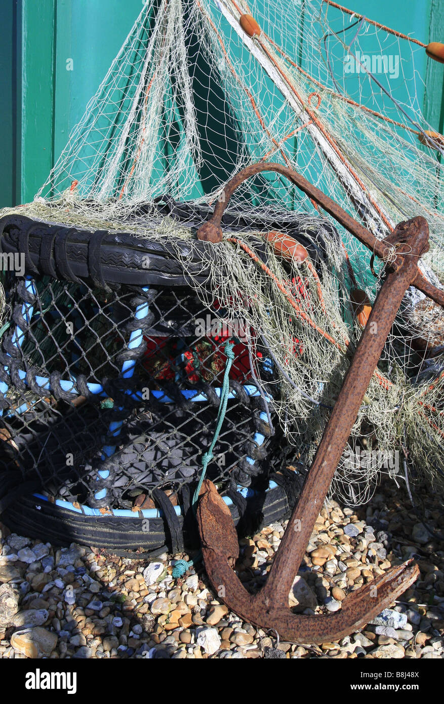 Lobster Pot und Anker in Fischernetzen. Stockfoto