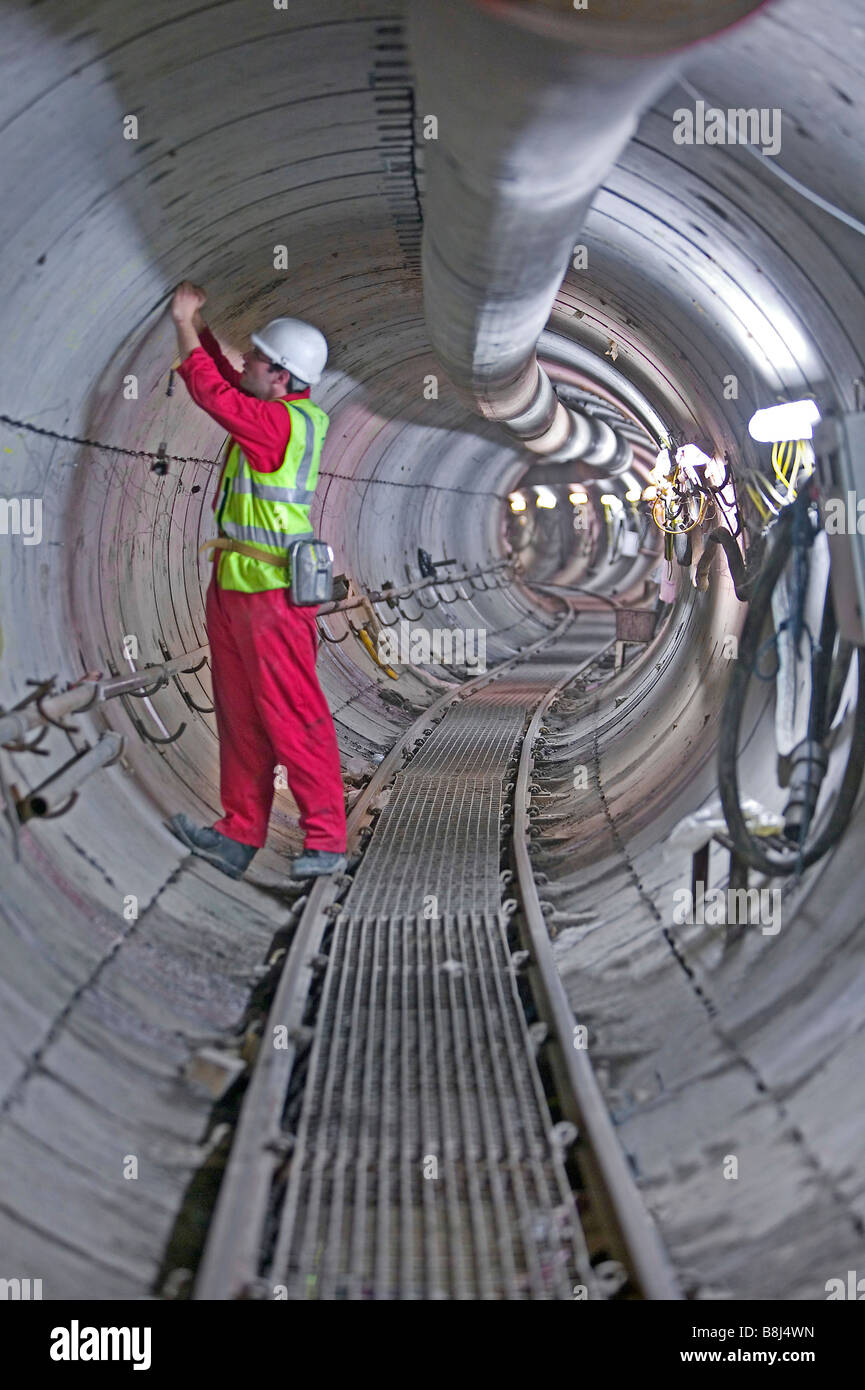Ingenieur inspiziert Betonsegmenten in diesen verwinkelten macht Kabel Tunnel ausgegraben durch eine Tunnelbohrmaschine installiert. Stockfoto