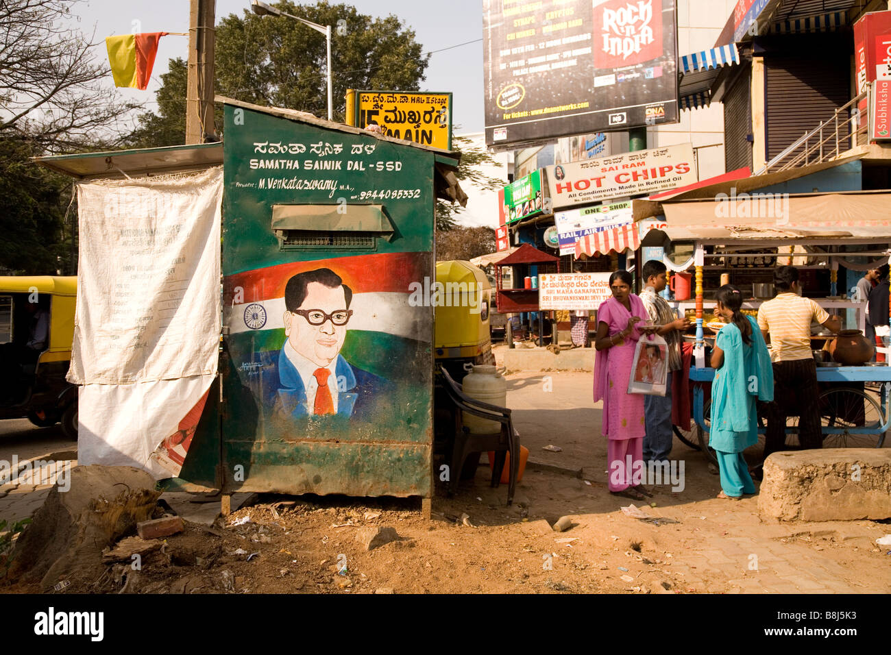 A Straßenszene in Bangalore, Indien. Eine Rikscha steht neben einem Schuster Stand zeigt der Architekt oder der indischen Verfassung. Stockfoto