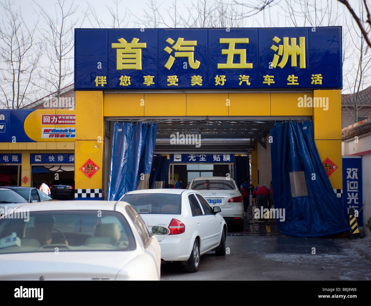 Autos, die Schlange, um automatische Autowäschemaschine in Peking China 2009 eingeben Stockfoto