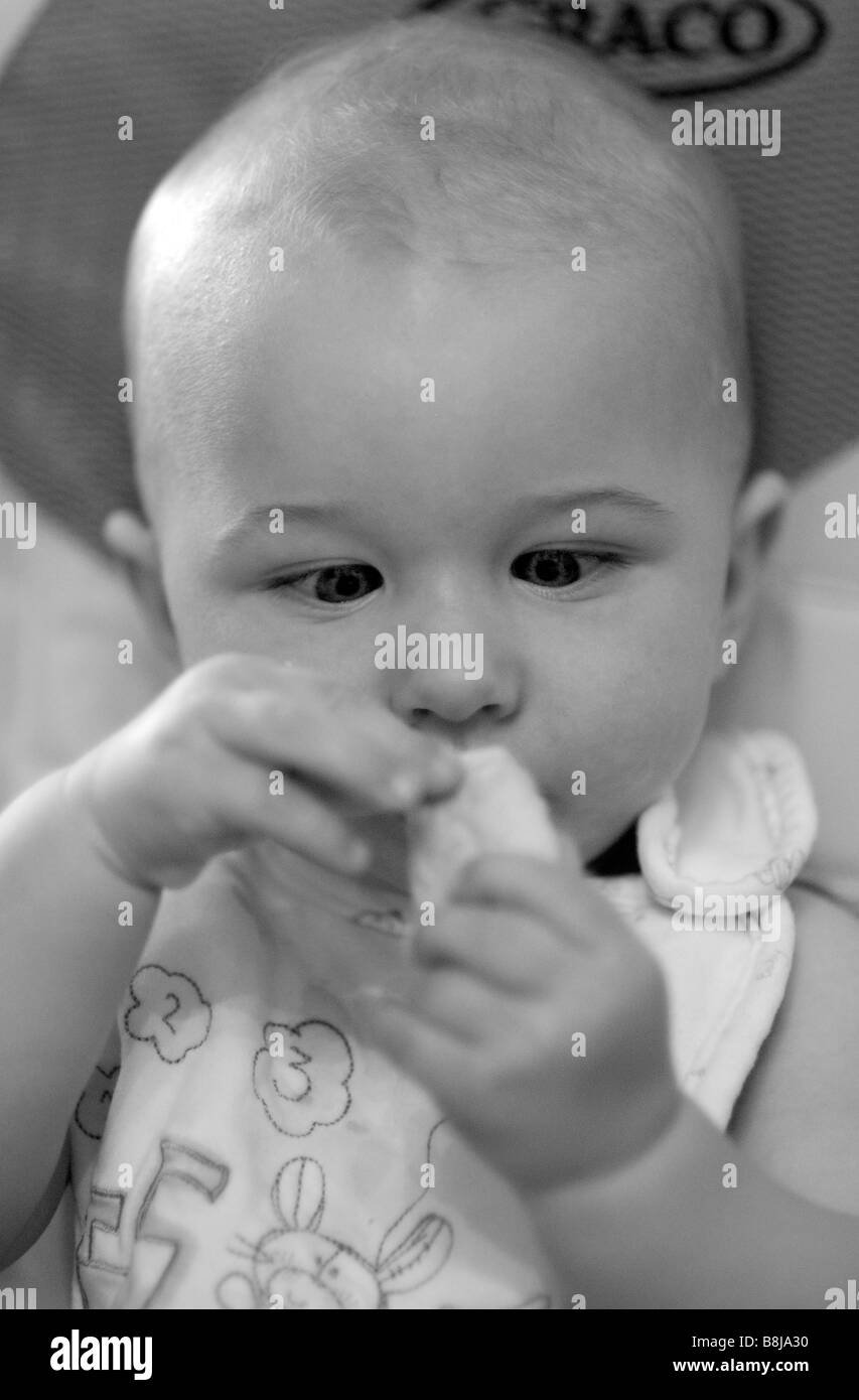 Ein kleinen Jungen geht Schielen während der Prüfung Bestandteil einer Zwieback und gefüttert. Stockfoto