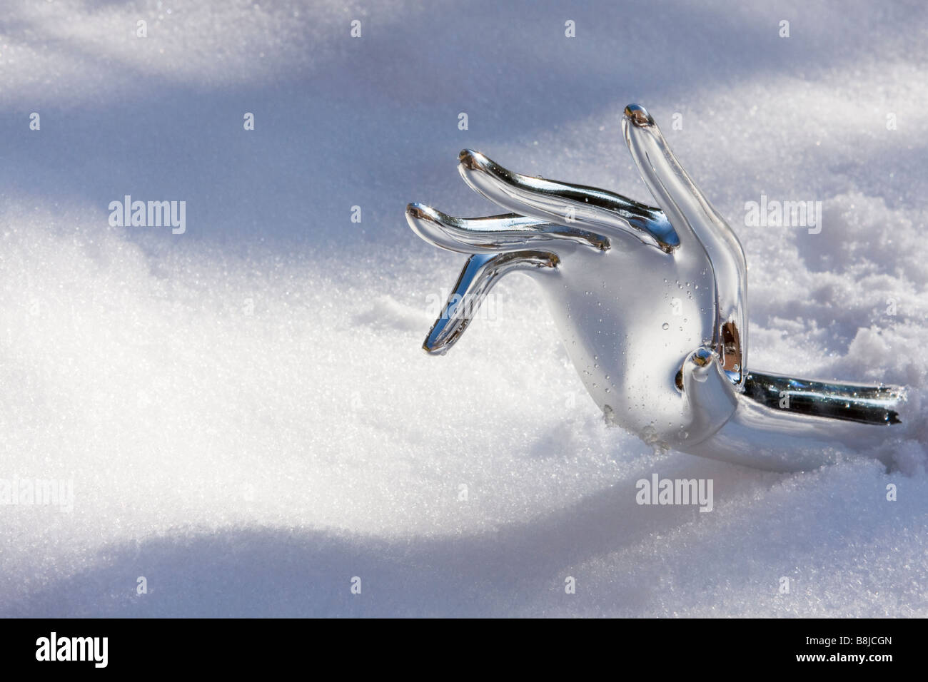 Metallisches Chrom Hand erreichen unter Schnee Stockfoto