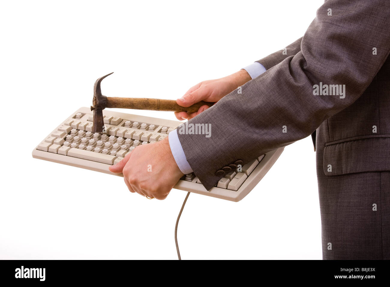 wütend Geschäftsmann zerstören eine Tastatur mit einem Hammer, isoliert auf weiss Stockfoto