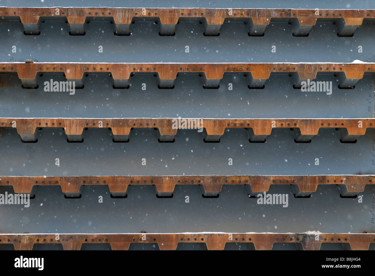 Schneefall über Verlegung Stapel Brücke Bauteile. Stockfoto