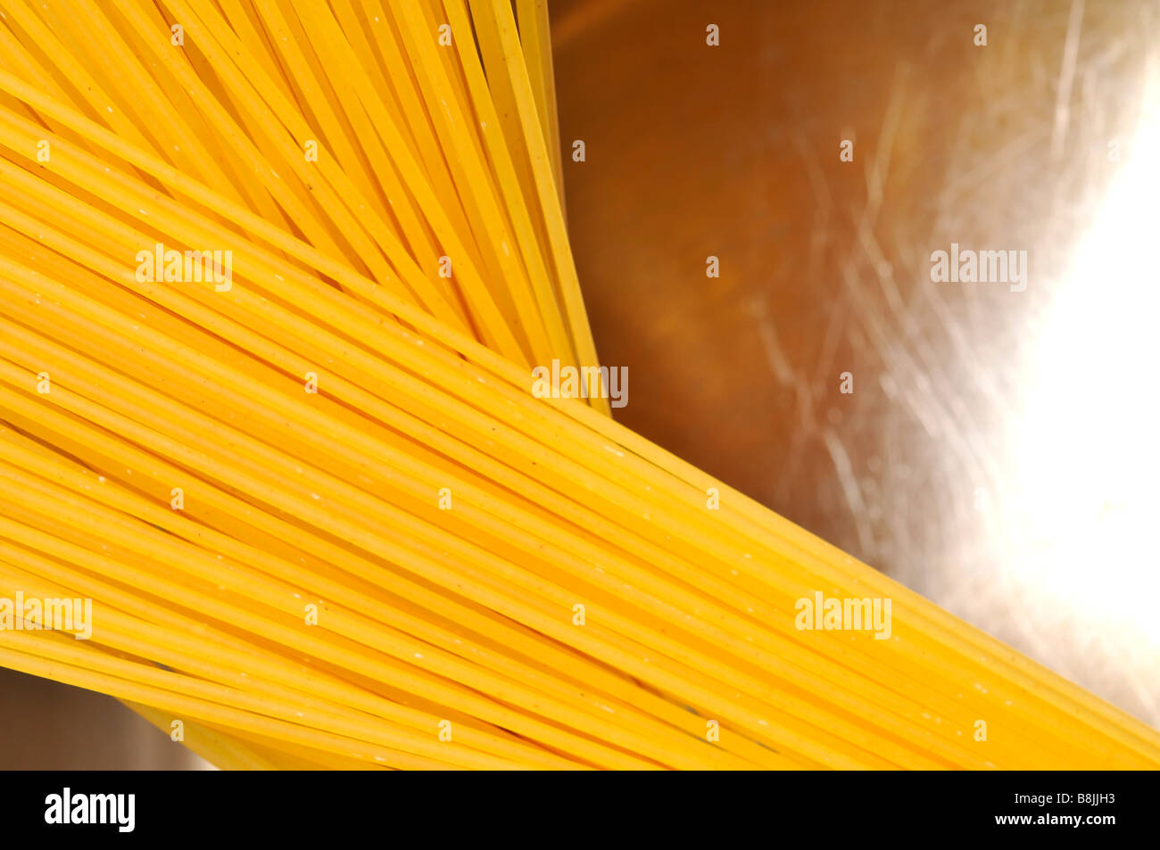 getrocknete Spaghetti in Edelstahl Pfanne ungekocht Rohwasser italienisches Essen Kohlenhydrate Bolognese Küchenutensil kochen weiß bac Stockfoto