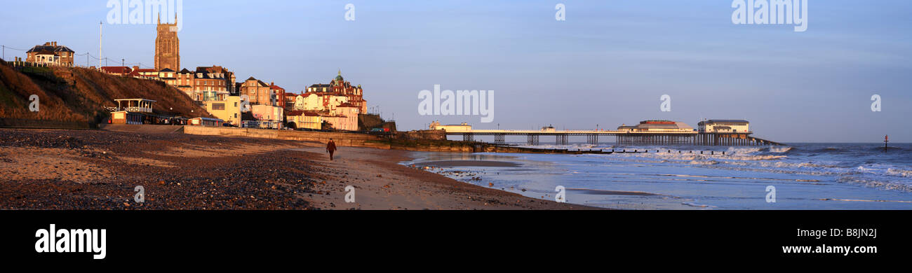 "Cromer" pan, Stadt, Strand und Pier mit einer einzelnen Person zu Fuß am Strand. Cromer, Norfolk, East Anglia, England, UK Stockfoto