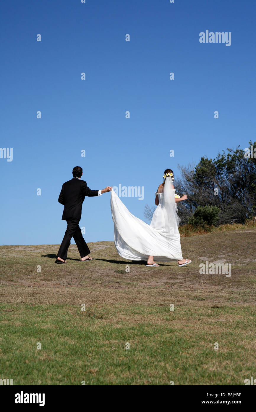 Frisch verheiratetes Paar mit Bräutigam trägt des Zuges der Braut Kleid Stockfoto