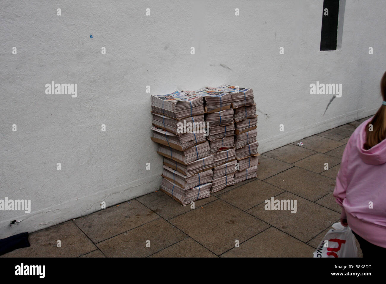 Ein Haufen von nicht verkauften Zeitungen zusammengefasst auf der Straße in Manchester Stockfoto