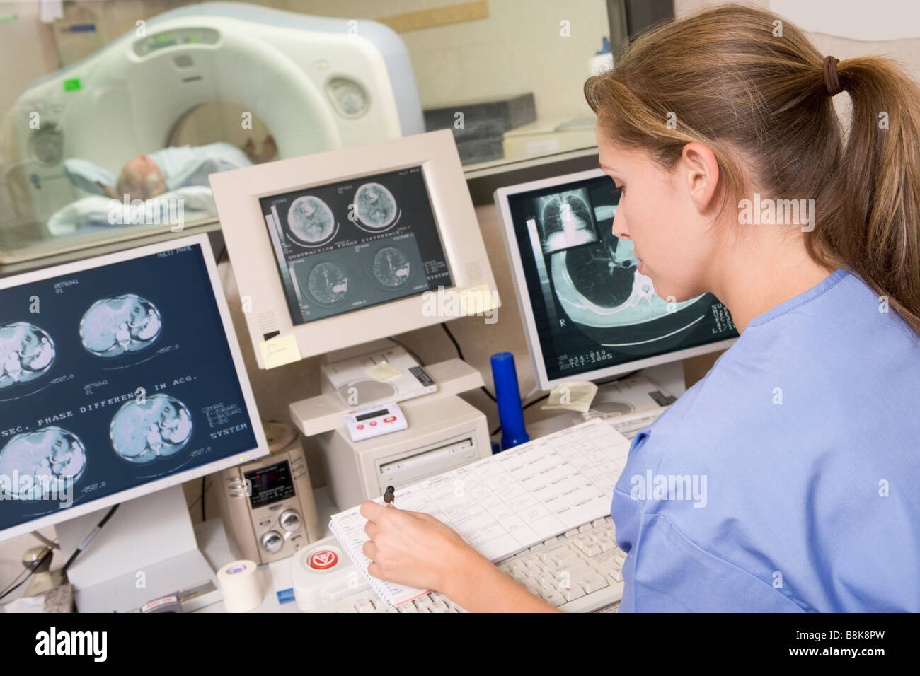 Scannen Sie Krankenschwester Überwachung Patient mit einer Computertomographie Axial (CAT) Stockfoto