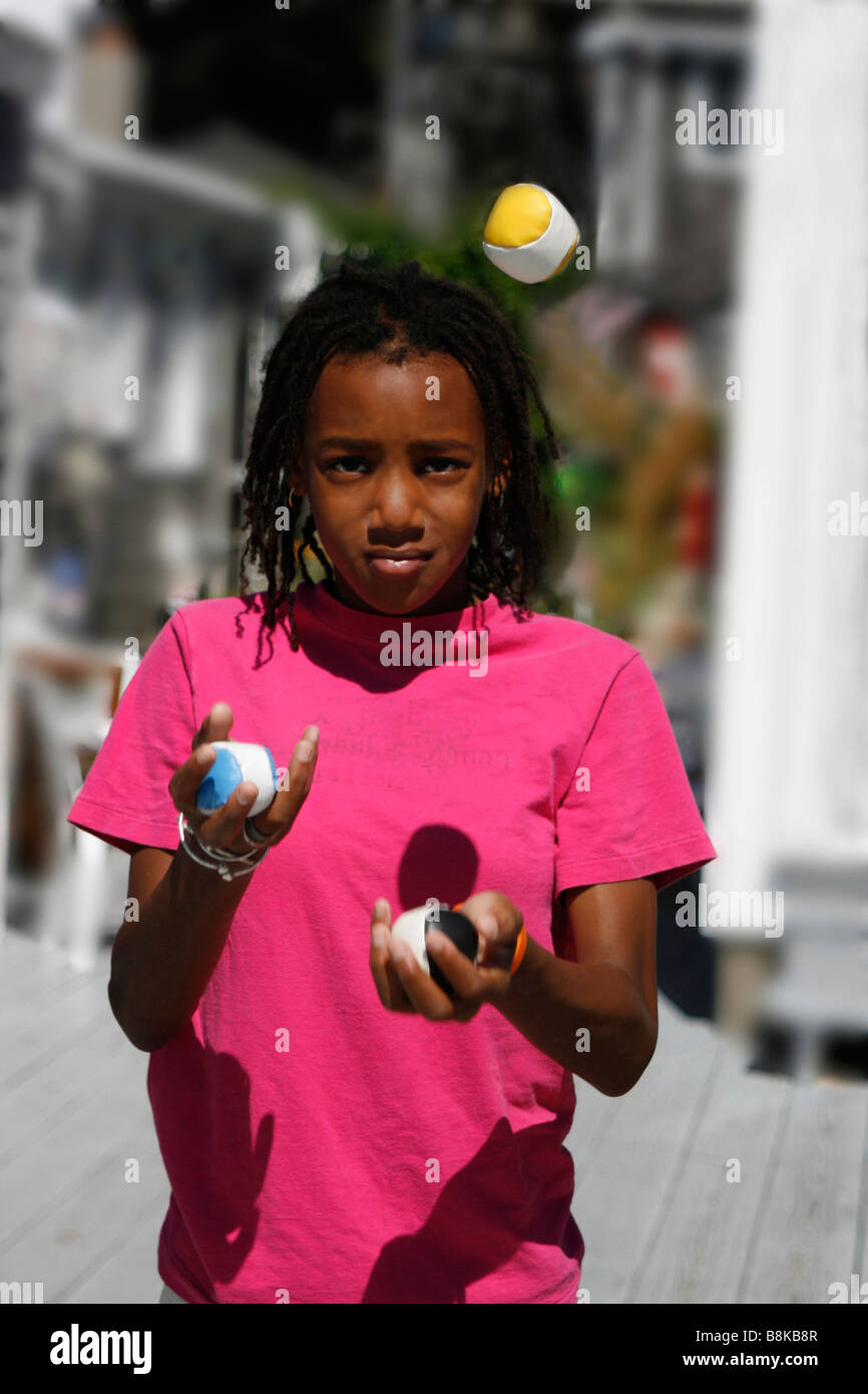 Elf Jahre alte schwarze Amerikanerin drei Jonglierbälle. Model Released Stockfoto