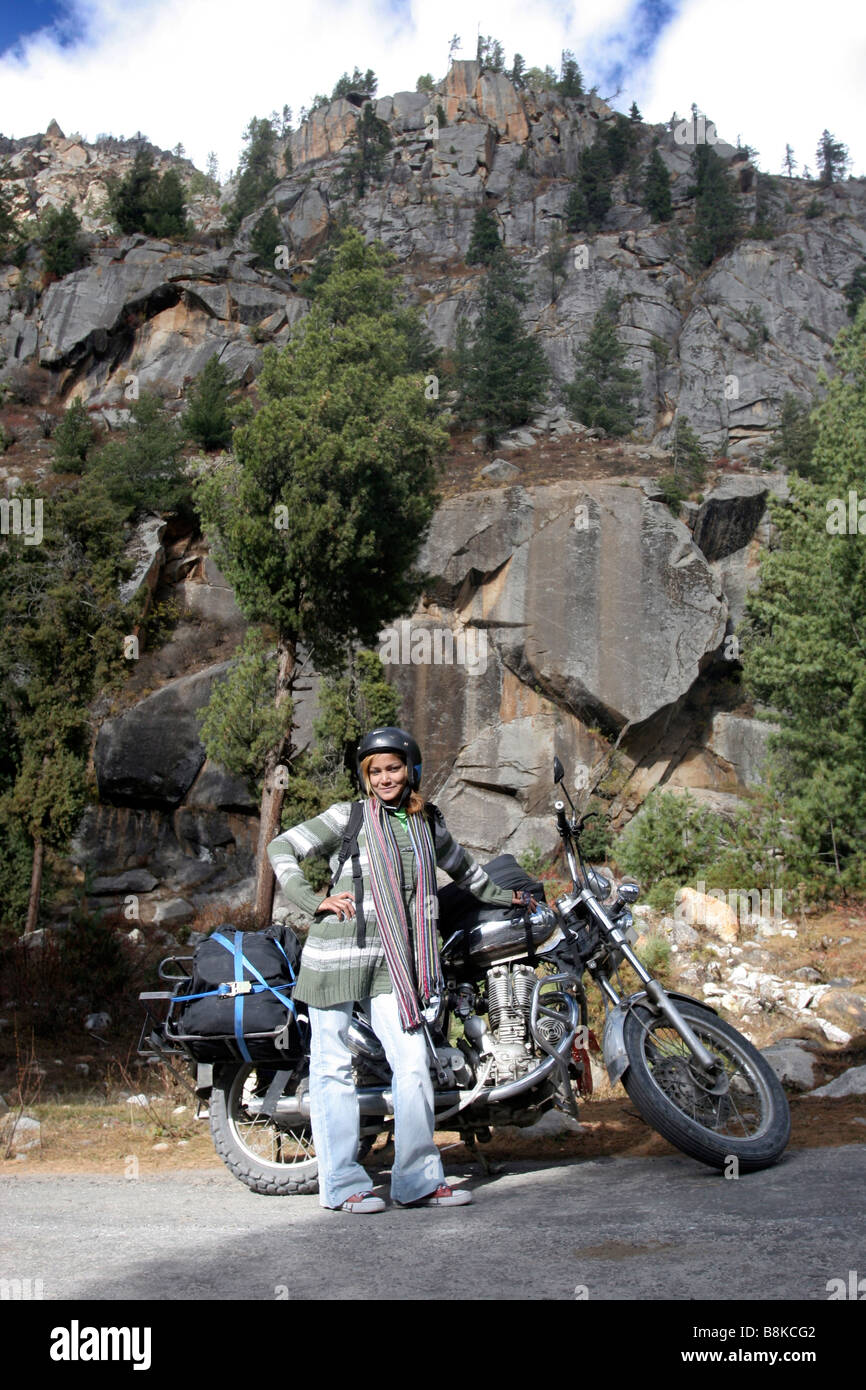 Eine Mädchen steht neben einer Enfield Thunderbird Motorrad während einer Fahrt im Sangla Tal von Himachal Pradesh in Indien Stockfoto