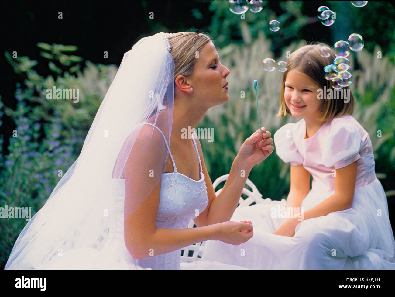 Braut und Blumenmädchen Seifenblasen. Stockfoto