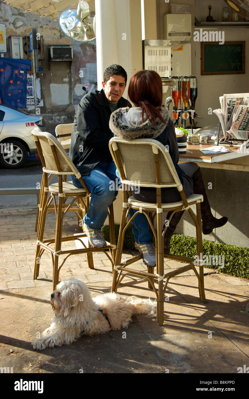 Paar mit Hund genießen eine Kaffeepause an einem Open-Air Café Kiosk auf dem Zentrum Fußgängerzone Mittelstreifen von Rothschild Boulevard Stockfoto