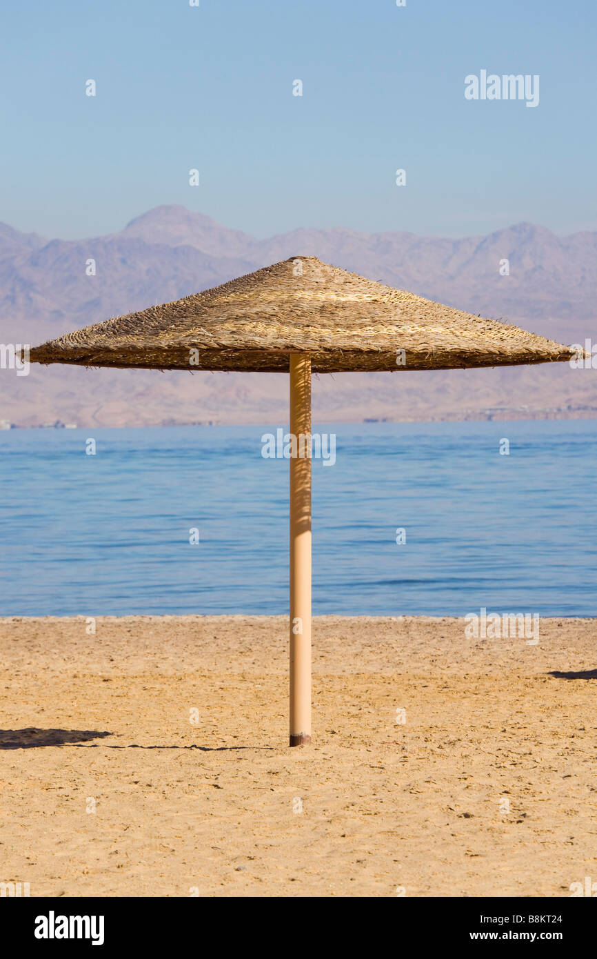 Ein Stroh Sonnenschirm am Sandstrand an der Küste des Roten Meeres. Taba Heights Sinai Ägypten Asien Stockfoto