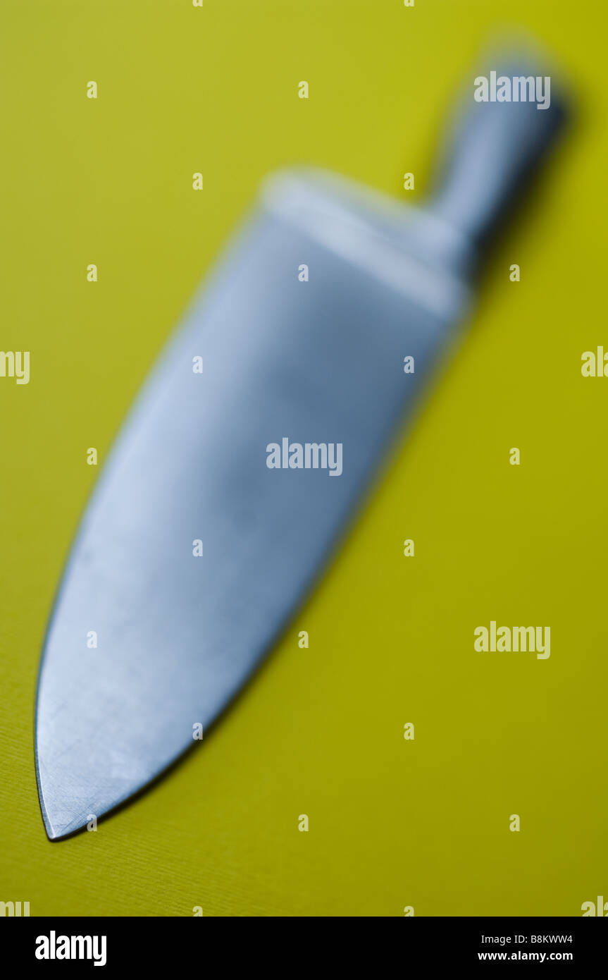 Ein Steakmesser Edelstahl platziert auf einem gelben Hintergrund. Stockfoto