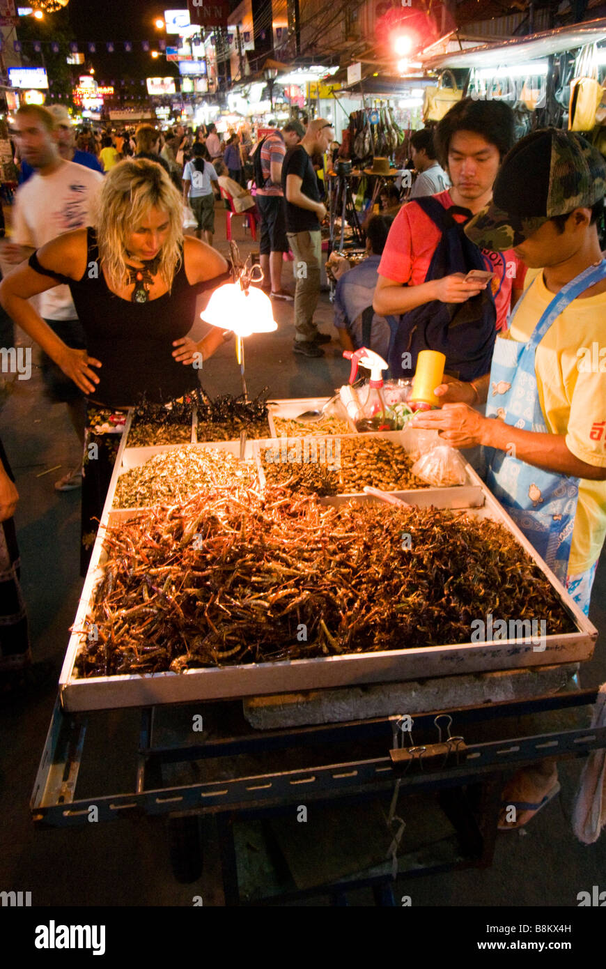 Touristen auf der Suche bei frittierten Insekten bei Nacht Markt Food stall Khao San Road in Bangkok Thailand Stockfoto