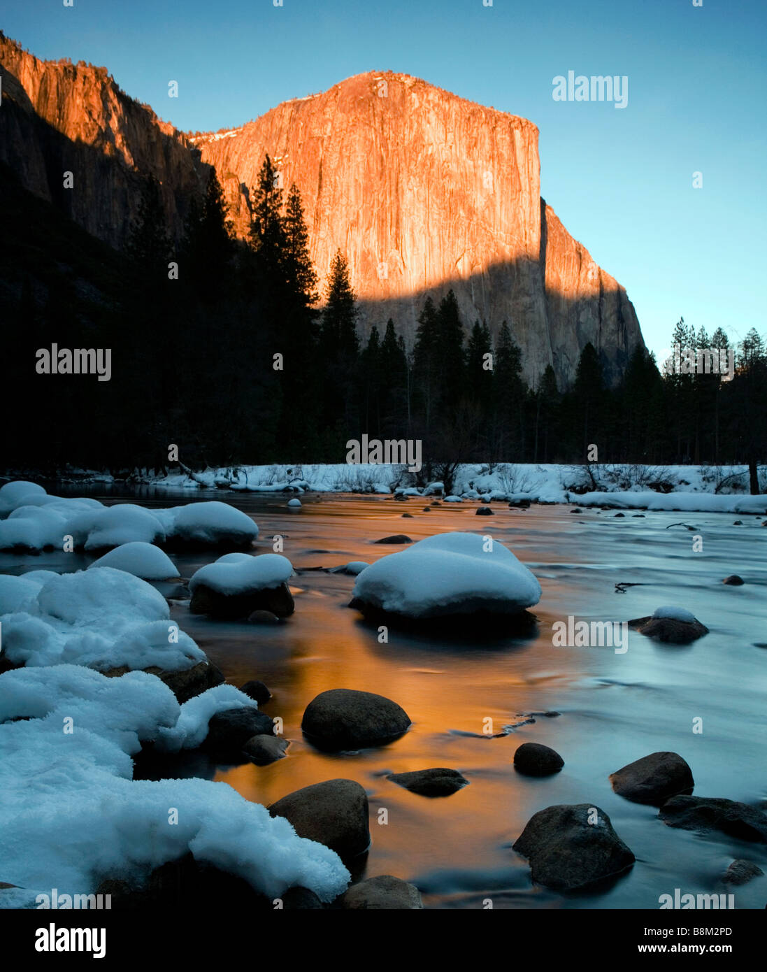 El Capitan und schneebedeckten Felsen im Merced Fluss bei Sonnenuntergang im Yosemite National Park, USA Stockfoto