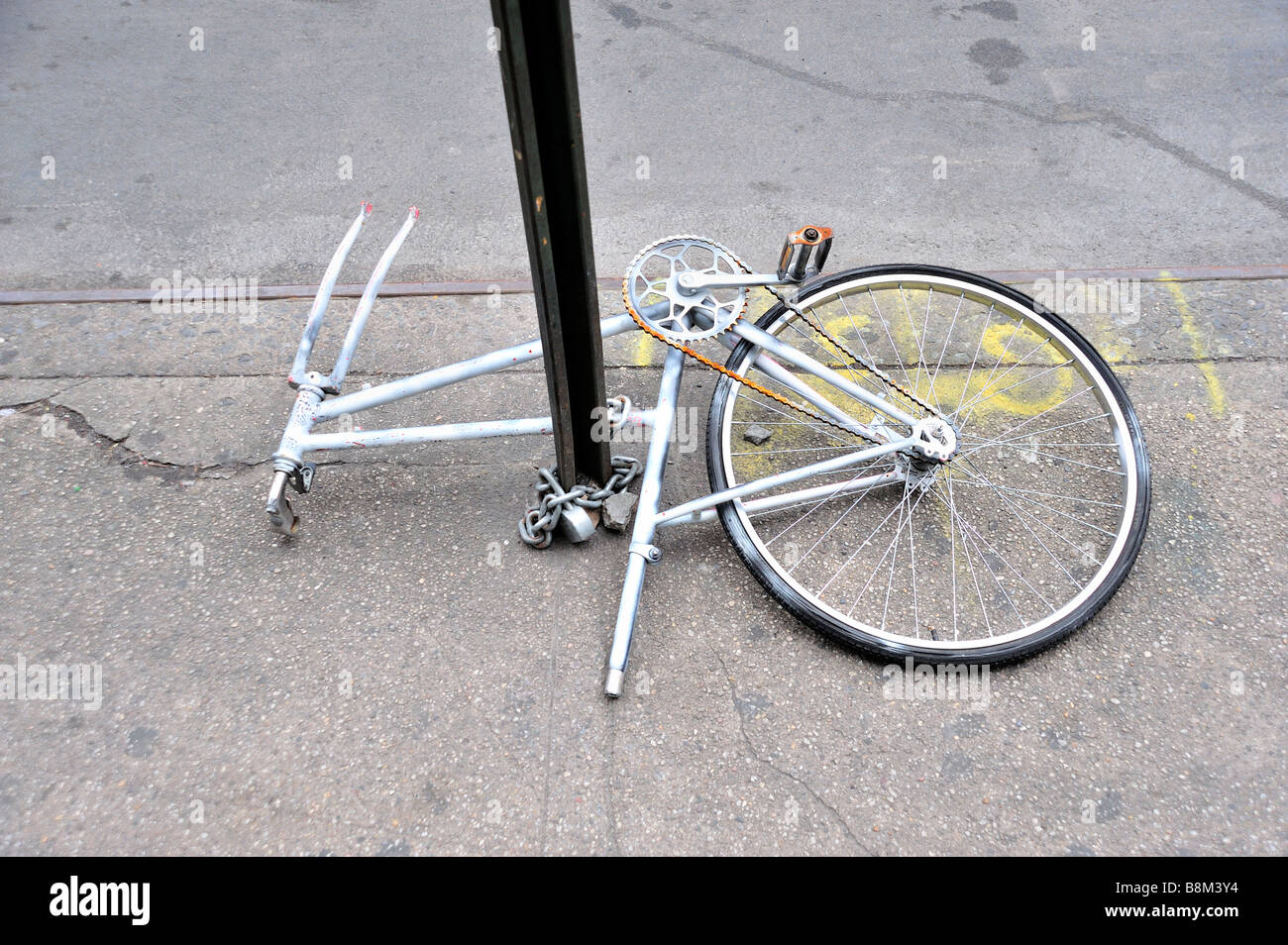 Ein Defekt Fahrrad angekettet an einen Wegweiser in New York City Stockfoto