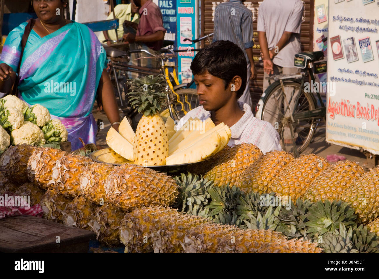 Indien-Tamil Nadu Tiruchirappalli Chinnar Basar junge Blick auf Ananasscheiben auf Marktstand Stockfoto