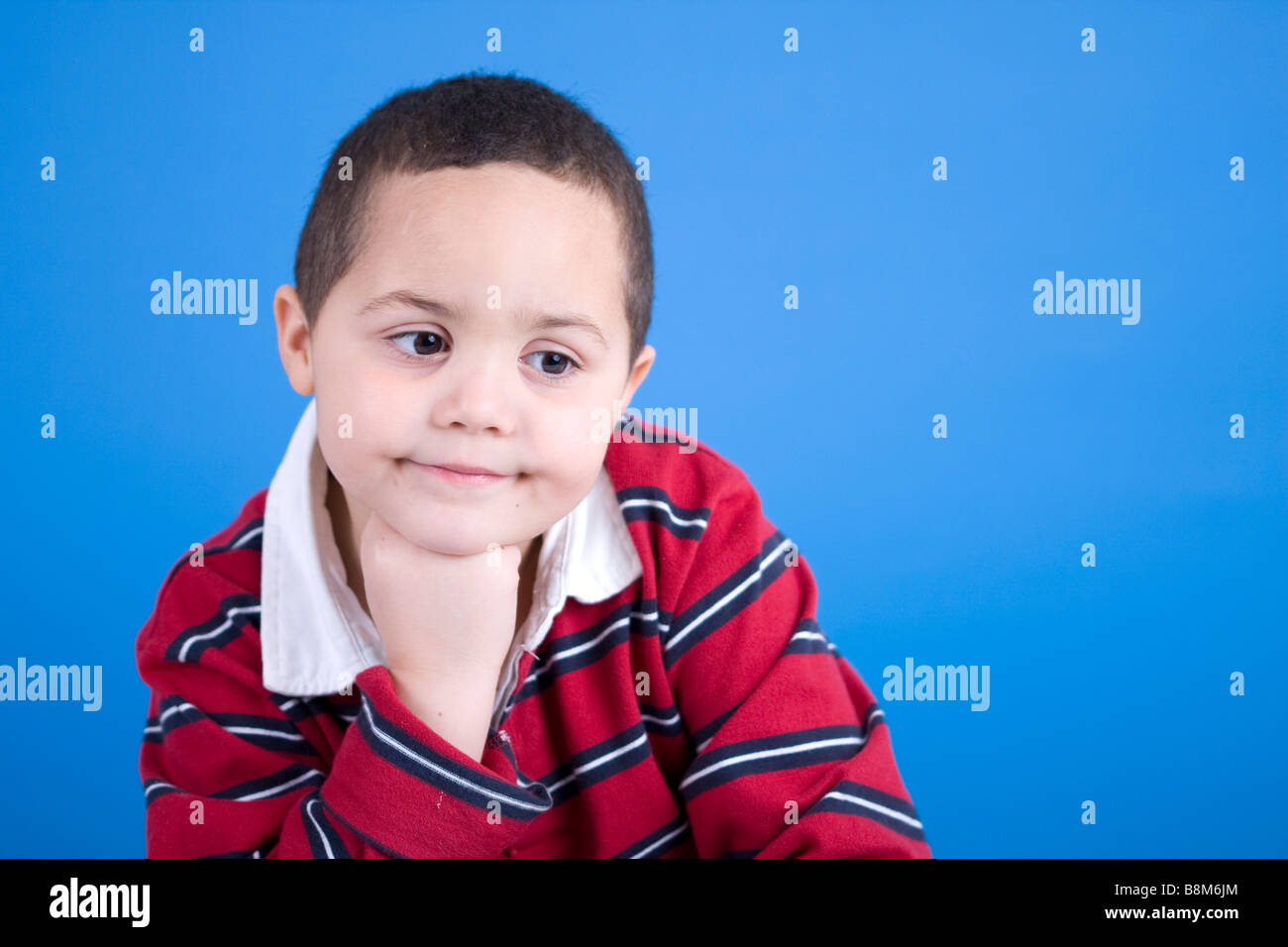 Latino Boy Studioportrait vor blauem Hintergrund Stockfoto