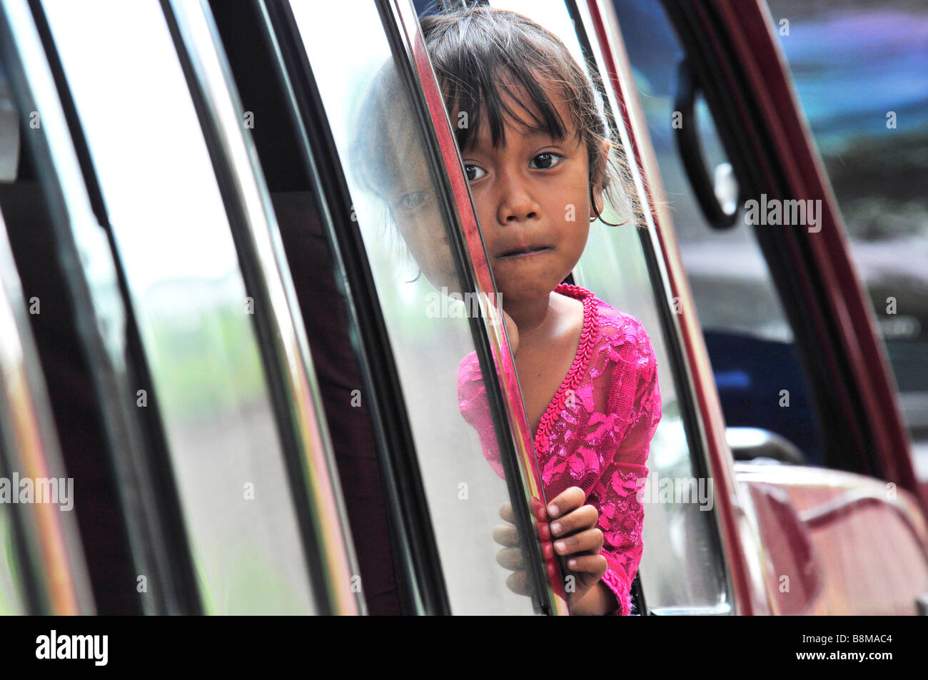 Balinesische Mädchen Käfer ihren Kopf aus dem Auto, Bali, Indonesien. Stockfoto