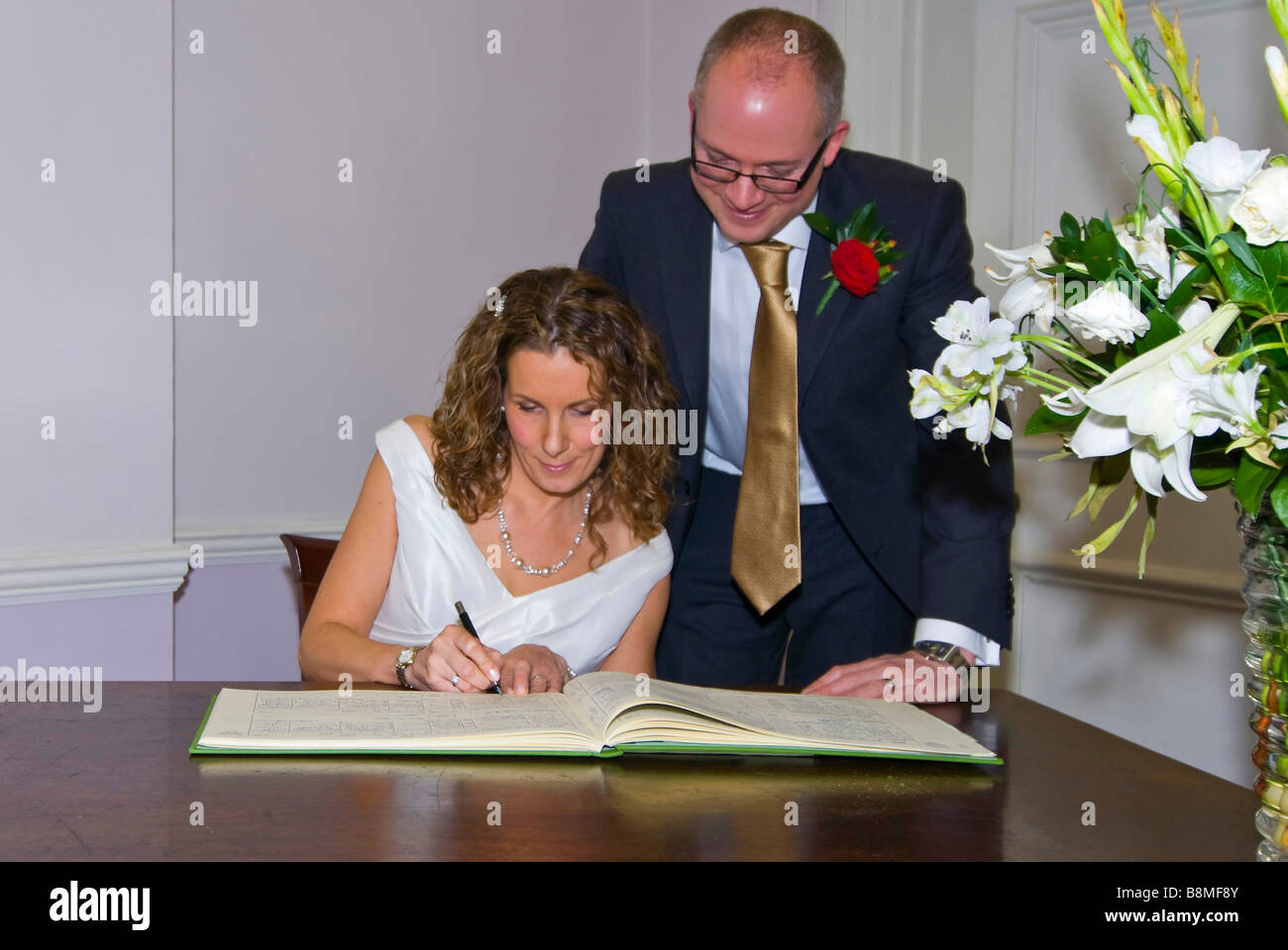 Horizontale Portrait einer Braut und Bräutigam, die Unterzeichnung der Register auf eine standesamtliche Trauung. Stockfoto