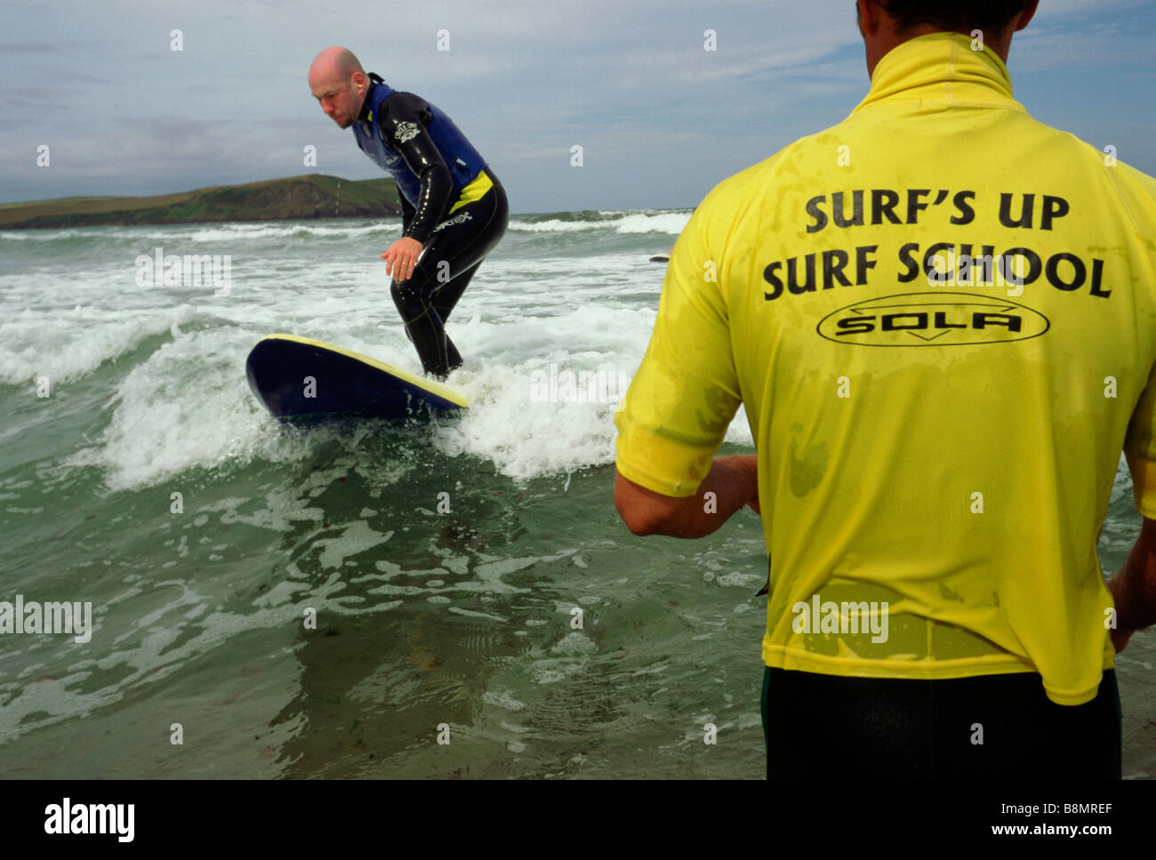 Polzeath Cornwall UK A Surflehrer Uhren einen Schüler Stockfoto