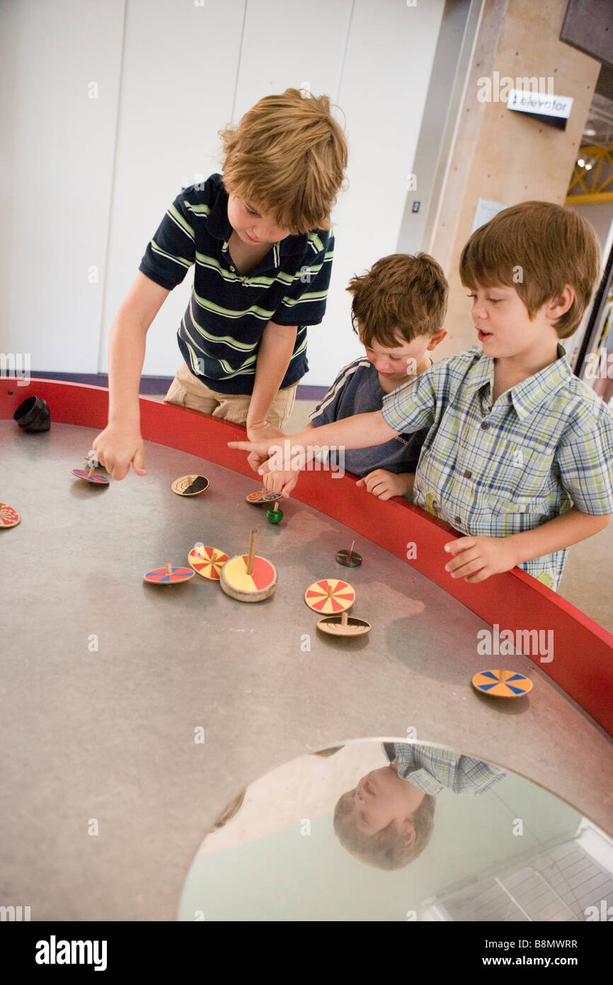 Kinder drehen eine Vielzahl von Spitzen auf einem Tisch Stockfoto