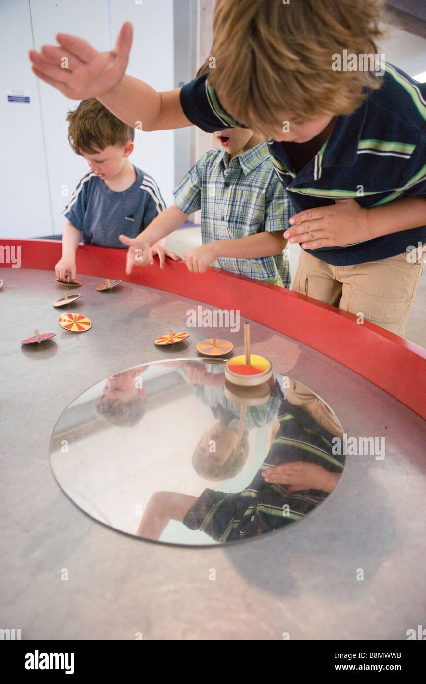 Kinder drehen eine Vielzahl von Spitzen auf einem Tisch Stockfoto