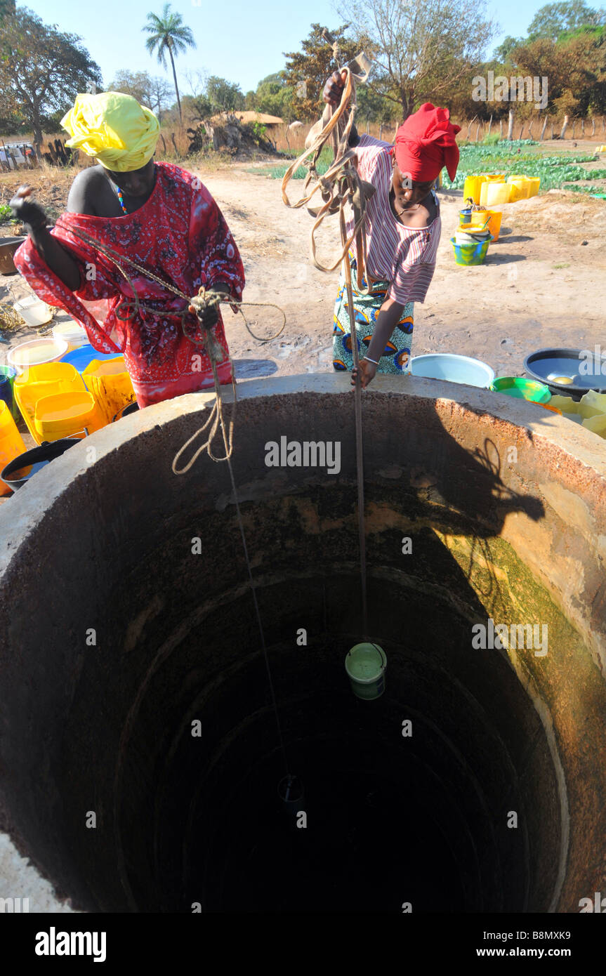 Frauen sammeln Wasser aus einem Brunnen Wasser ihre Pflanzen in Gambia, "Westafrika" Stockfoto