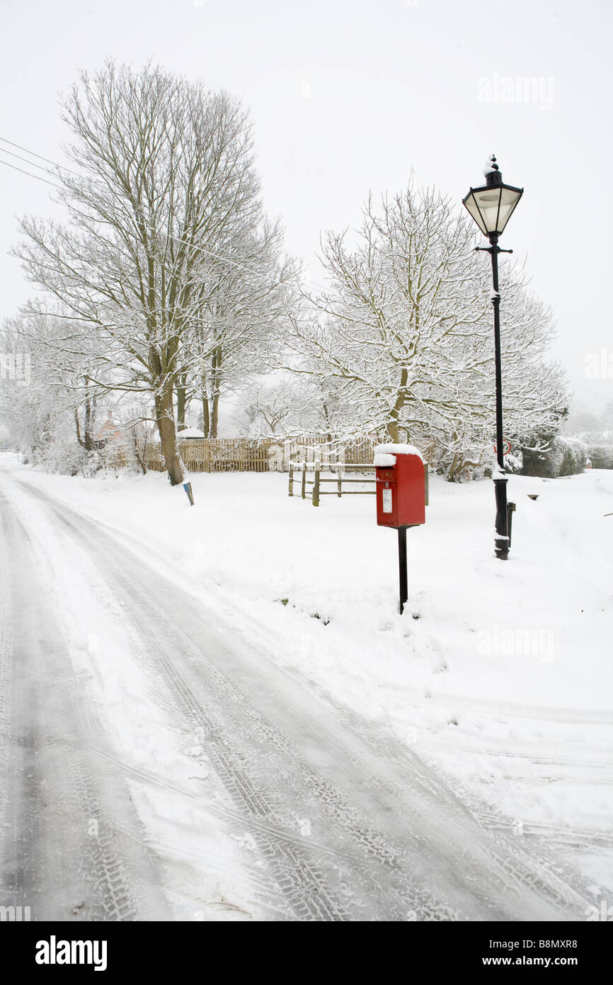 Traditionelle Schneeszene des Dorfes Askett, Buckinghamshire zeigt roten royal Mail-Postfach und Laternenpfahl Stockfoto