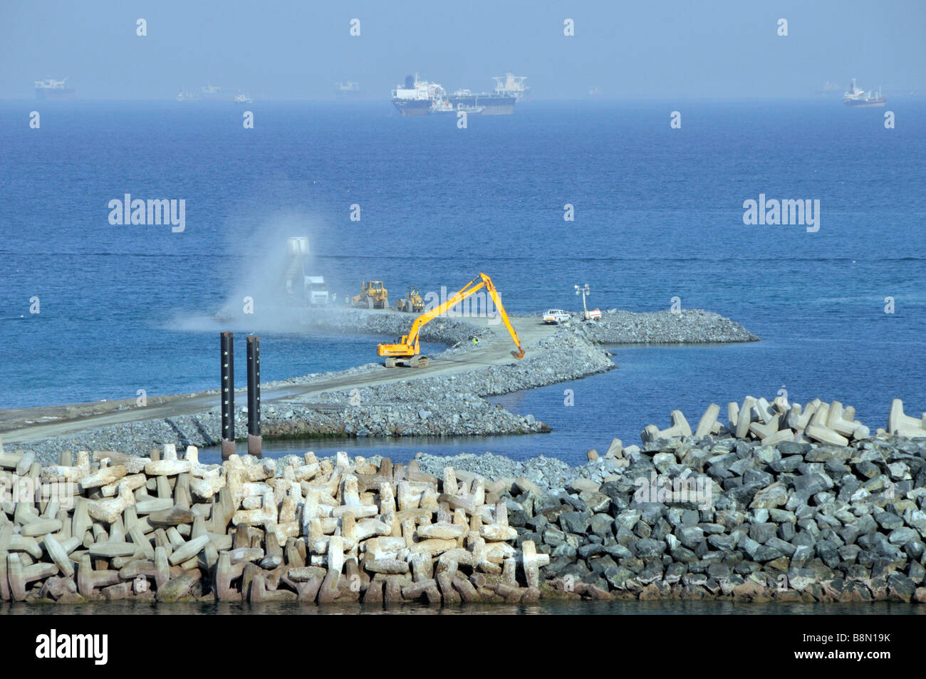Infrastrukturprojekt Erweiterung der Hafenanlagen mit Hafenschutzschiffen vom Typ Dolosse warten vor der Küste Fujairah Bunkerhafen Oman Golf VAE Stockfoto