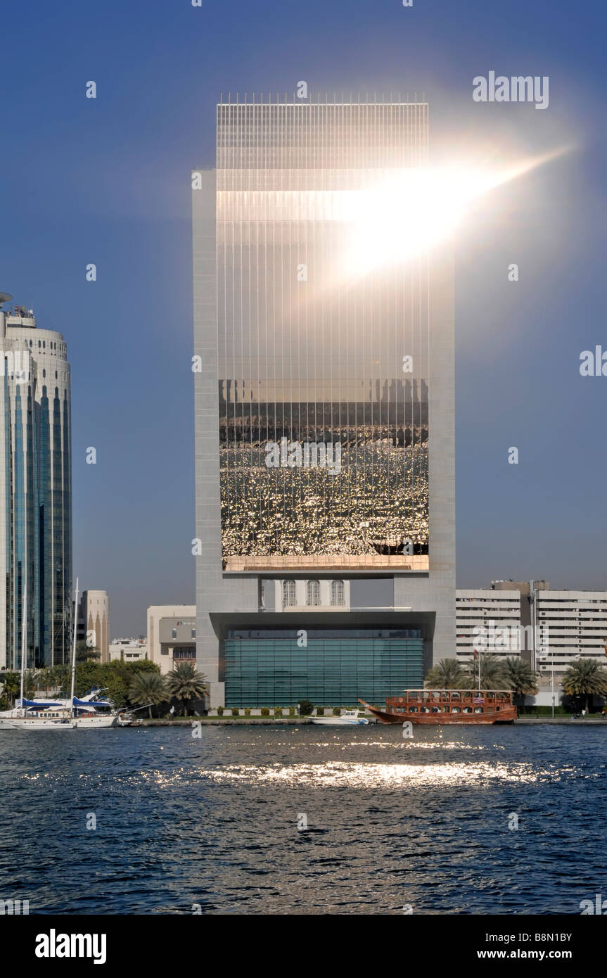 Dubai Creek und moderne Architektur Skyline mit geschwungener Front Der National Bank of Dubai und Sonne, die aus dem Glas aufflackernde Vereinigte Arabische Emirate VAE Stockfoto