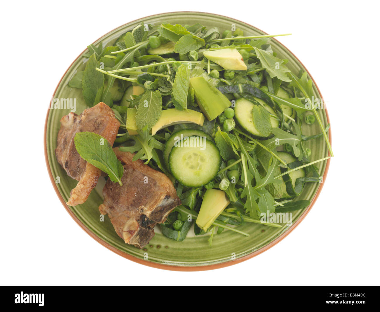 Ein frisch zubereitetes, zarte süße Lammkoteletts mit Avocado Salat und Rucola Blätter gegen einen weißen Hintergrund mit keine Menschen und einen Freistellungspfad isoliert Stockfoto