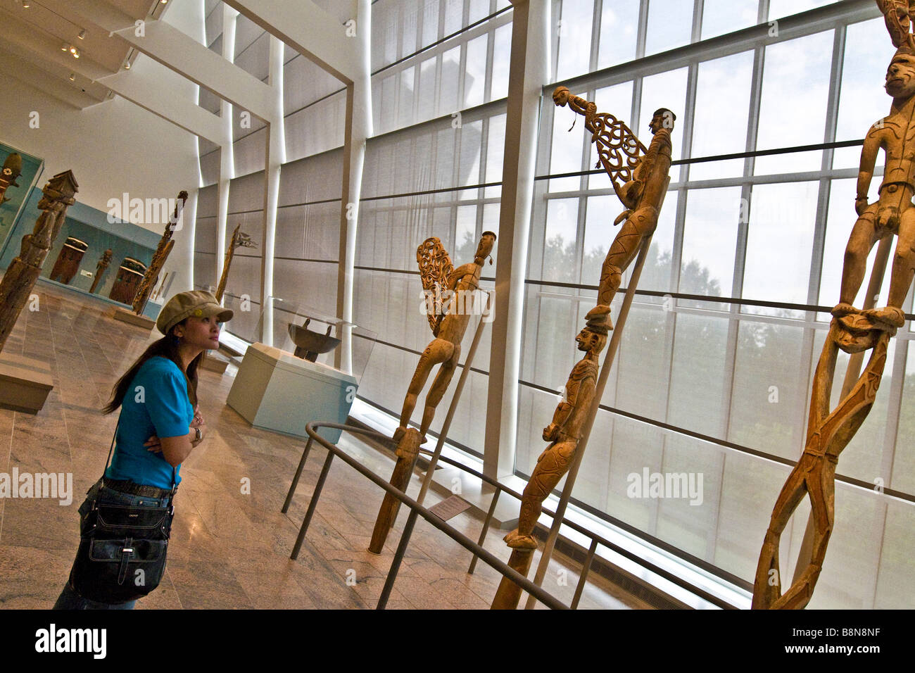 Besucher betrachten eine Ausstellung von geschnitzten Holzskulpturen im Metropolitan Museum of Art Stockfoto