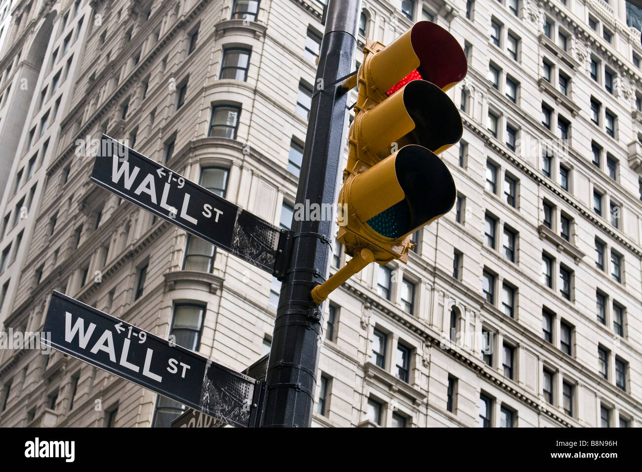 Rote Ampel und Straßenschilder mit Hochhaus im Hintergrund an Wall Street in Manhattan Stockfoto
