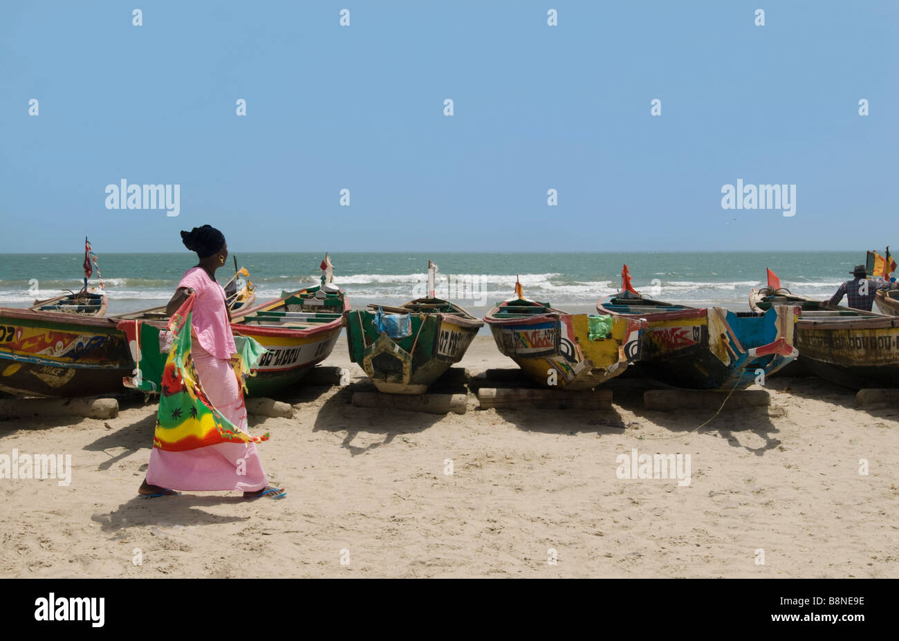 Fischen Sie Boote am Strand mit Frau in rosa Tracht zu Fuß Casamance Cap skirring Stockfoto