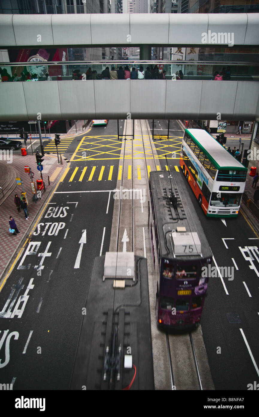 Double Decker Trolleys und Bus vorbei unter erhöhten Fußgängerweg Hong Kong s Central district Stockfoto