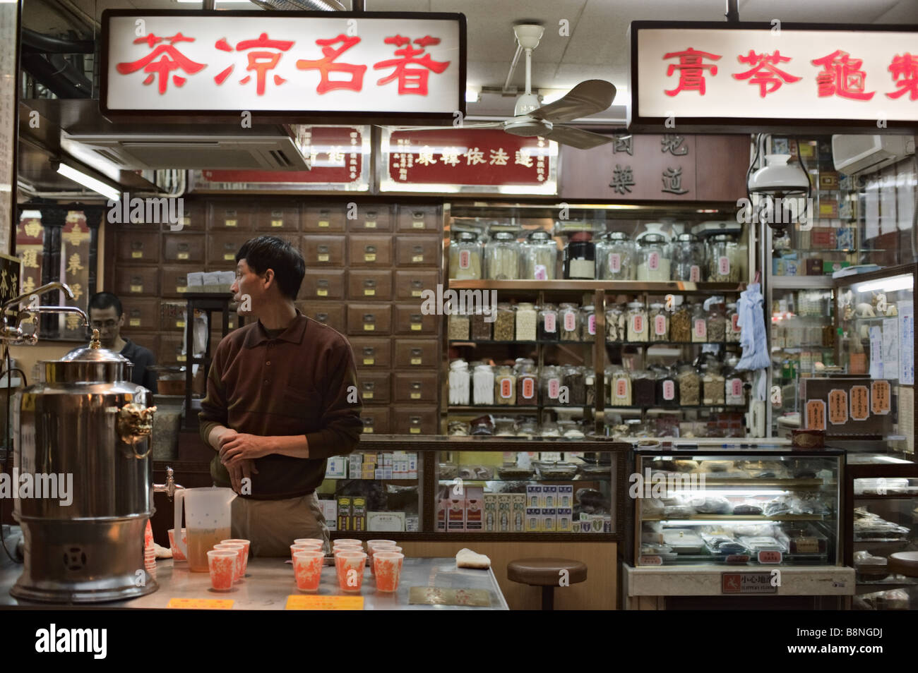 Mann hinter der Theke im Tee Shop, Hong Kong Stockfoto