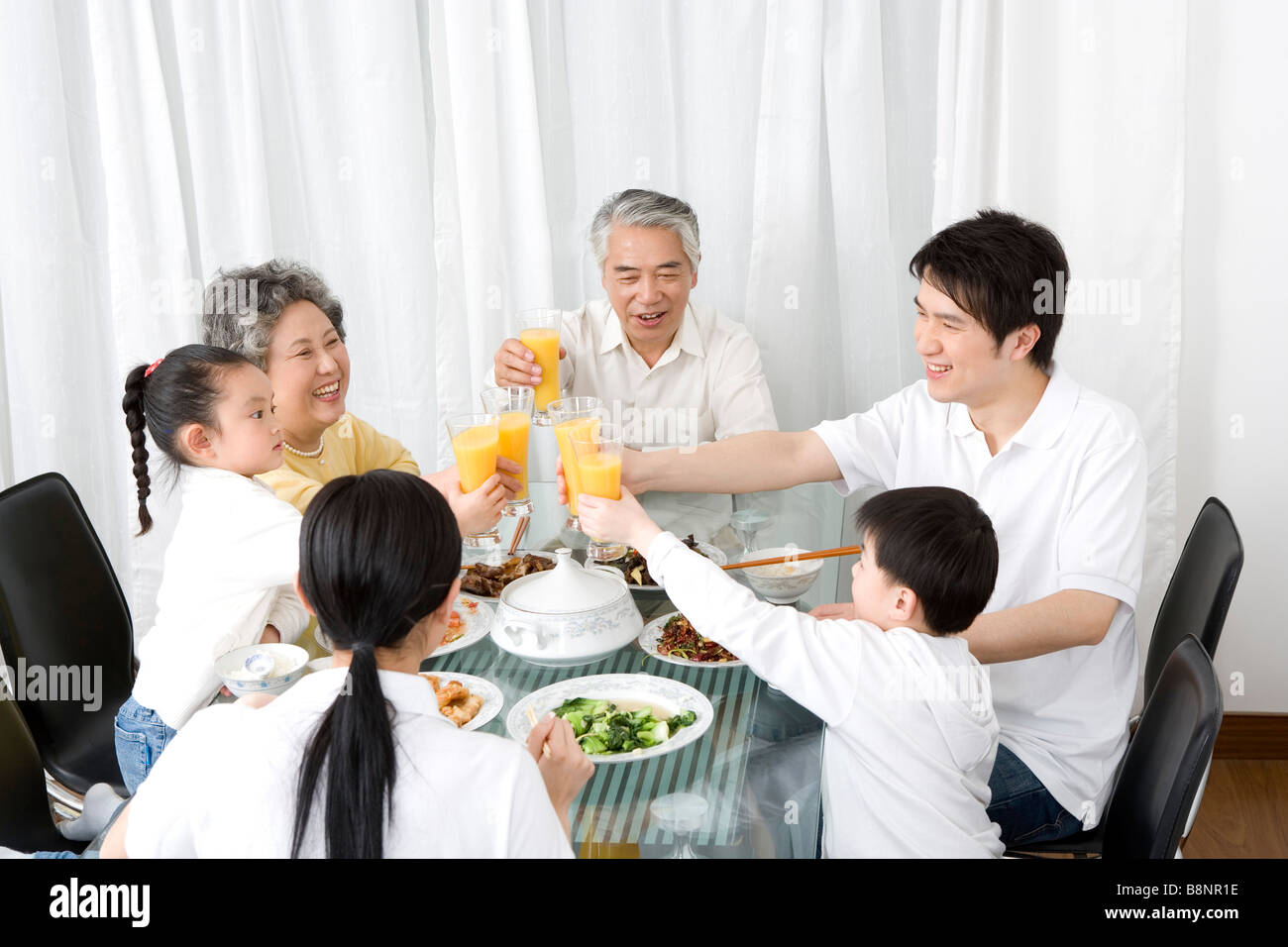 Drei-Generationen-Familie Mahlzeit und Toasten Stockfoto