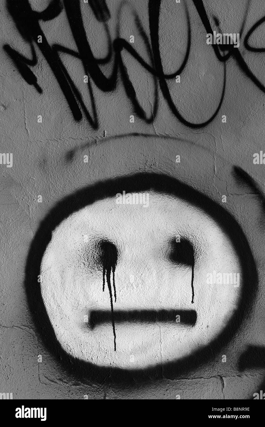 Graffiti-Smiley Smiley auf Betonmauer, Vandalismus, bedrohliche Augen Aussehen sie Blutungen sind. Urban Decay Ghetto Slum Verbrechen Stockfoto