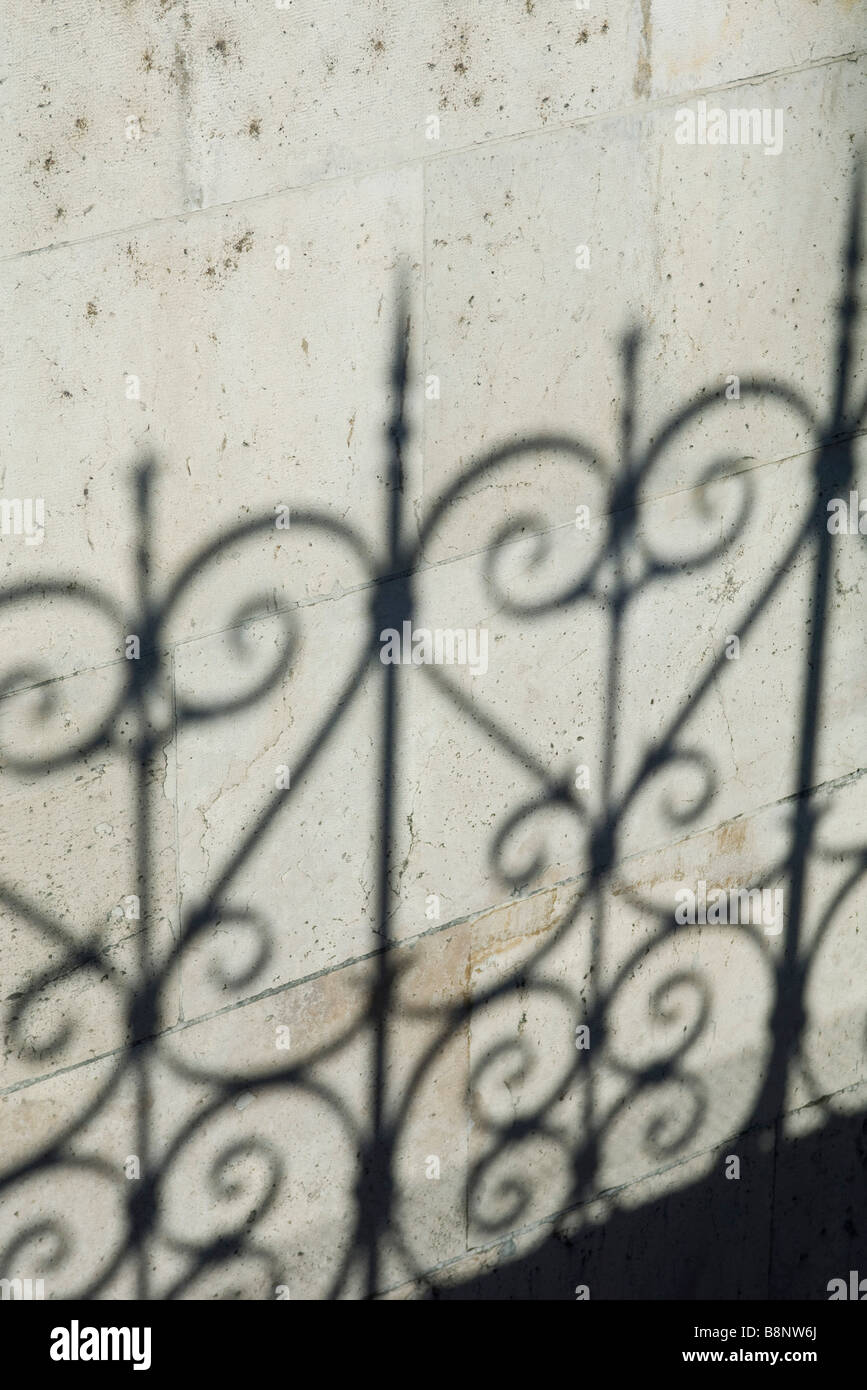 Schatten des reich verzierten Zaun an Wand Stockfoto