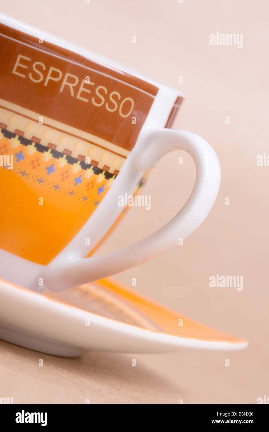 Orange Espressotasse auf Ocker Hintergrund Stockfoto