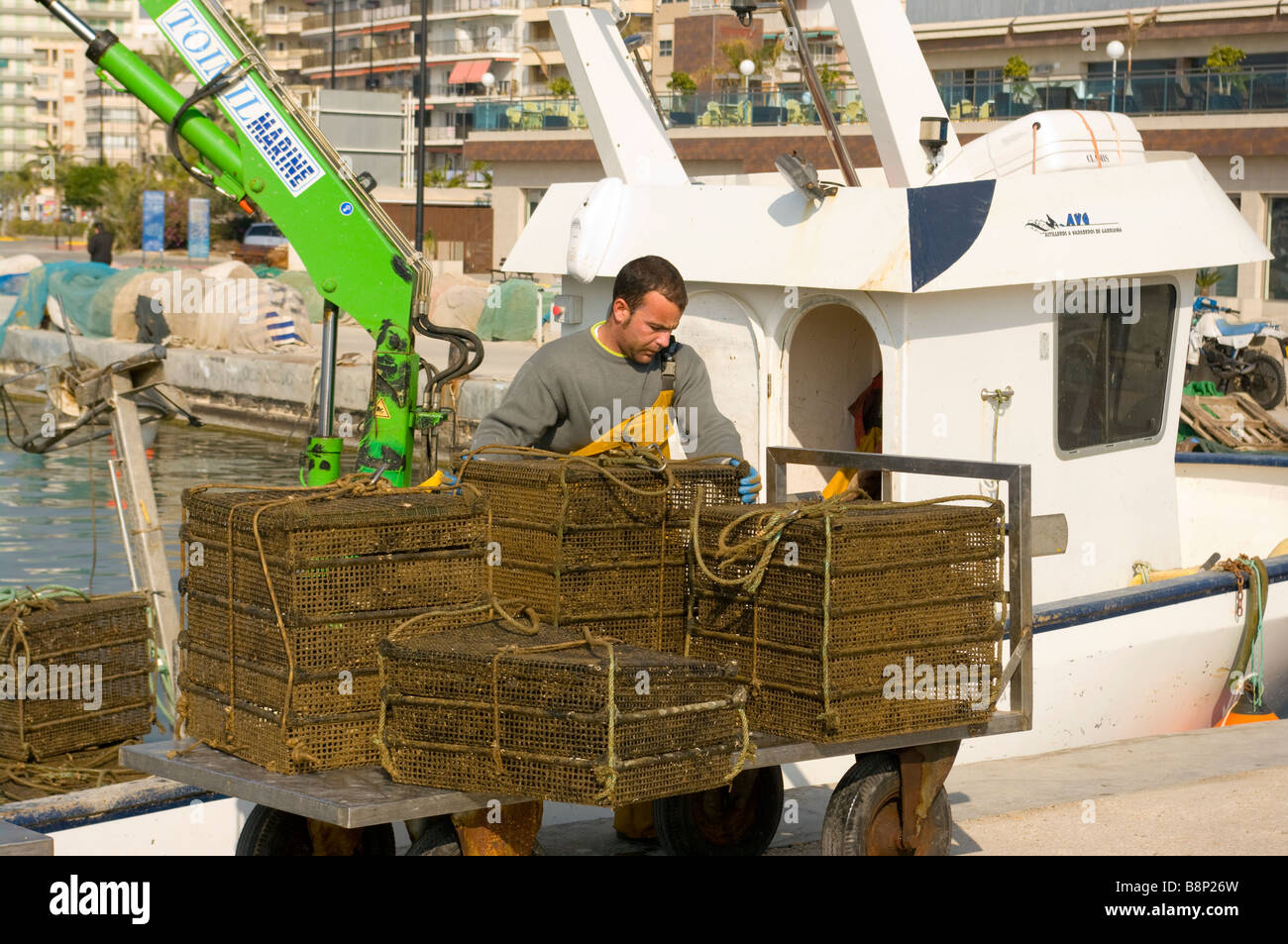 Berufsfischer Fischen Bootscrew entladen ihre Oyster fangen mit ein hydraulische Seilwinde in Santa Pola Hafen Spanien Stockfoto