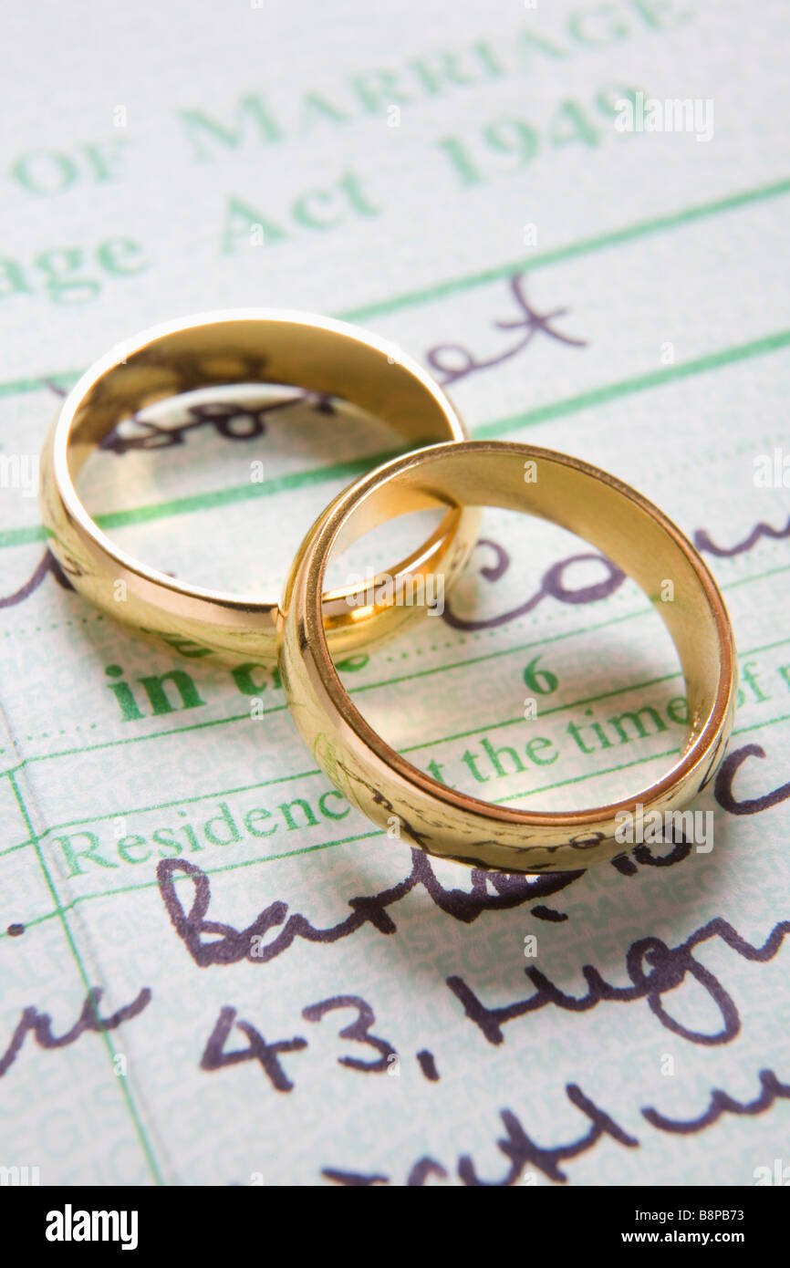Paar Gold Trauringe auf Heiratsurkunde Stockfoto